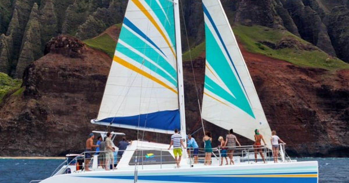 Catamaran sailing beneath the cliffs of the Na Pali Coast on Kauai