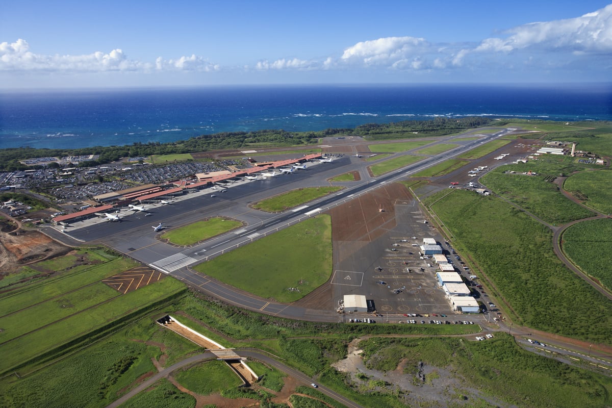 Aerial view of Kahului Airport on Maui, with the single runway, terminal, and the north shore coastline beyond