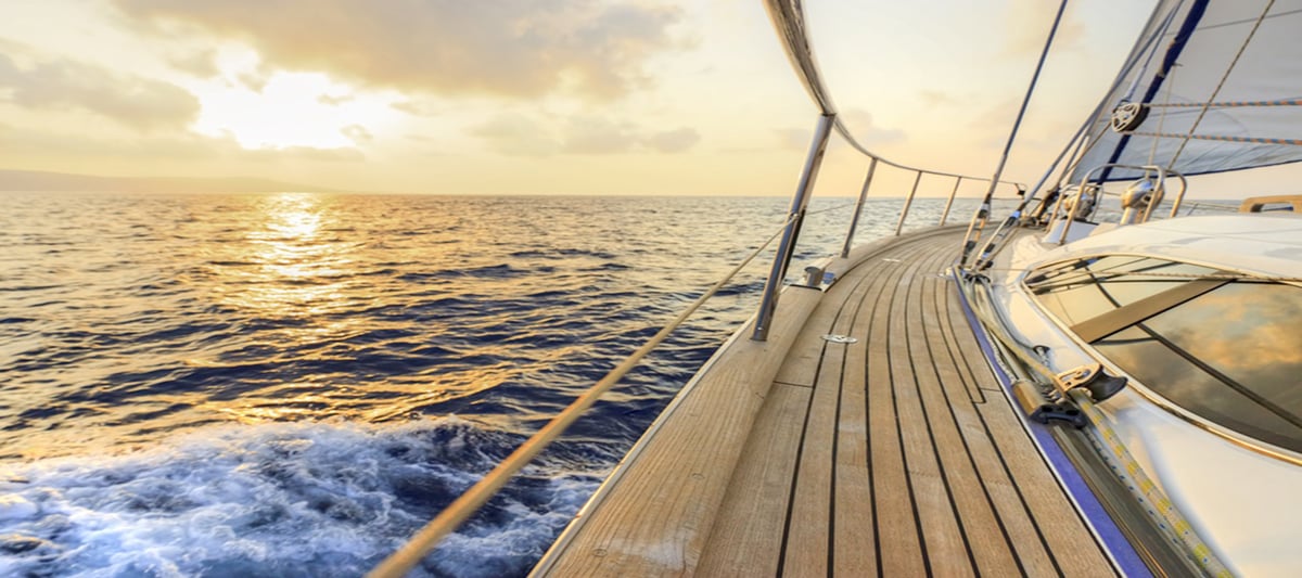 A sailboat deck at sunset on the water in Hawaii.