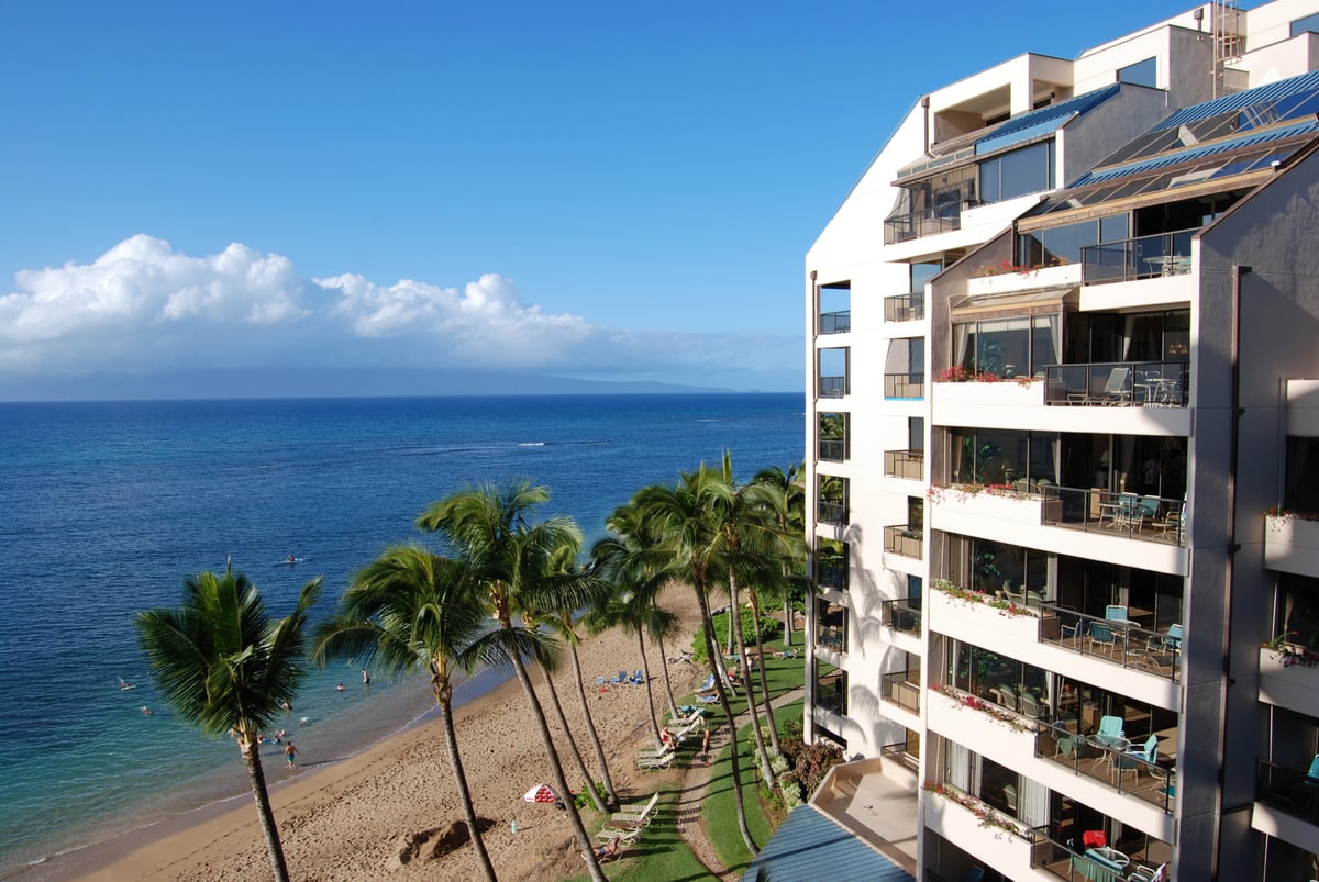 Oceanfront Maui lodging building above a beach with Lanai visible across the channel