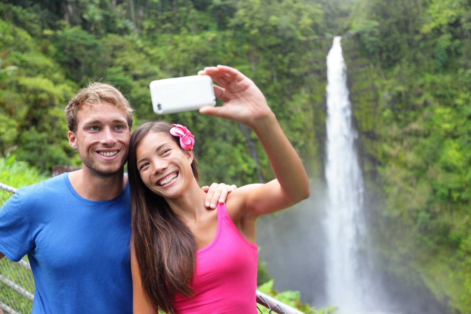 Travelers taking a photo at a Big Island waterfall overlook