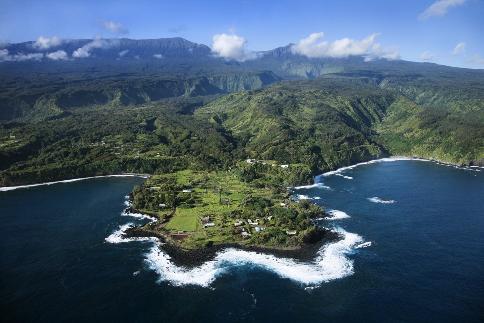 Small scenic-tour plane in flight over Maui's West Maui Mountains and coast