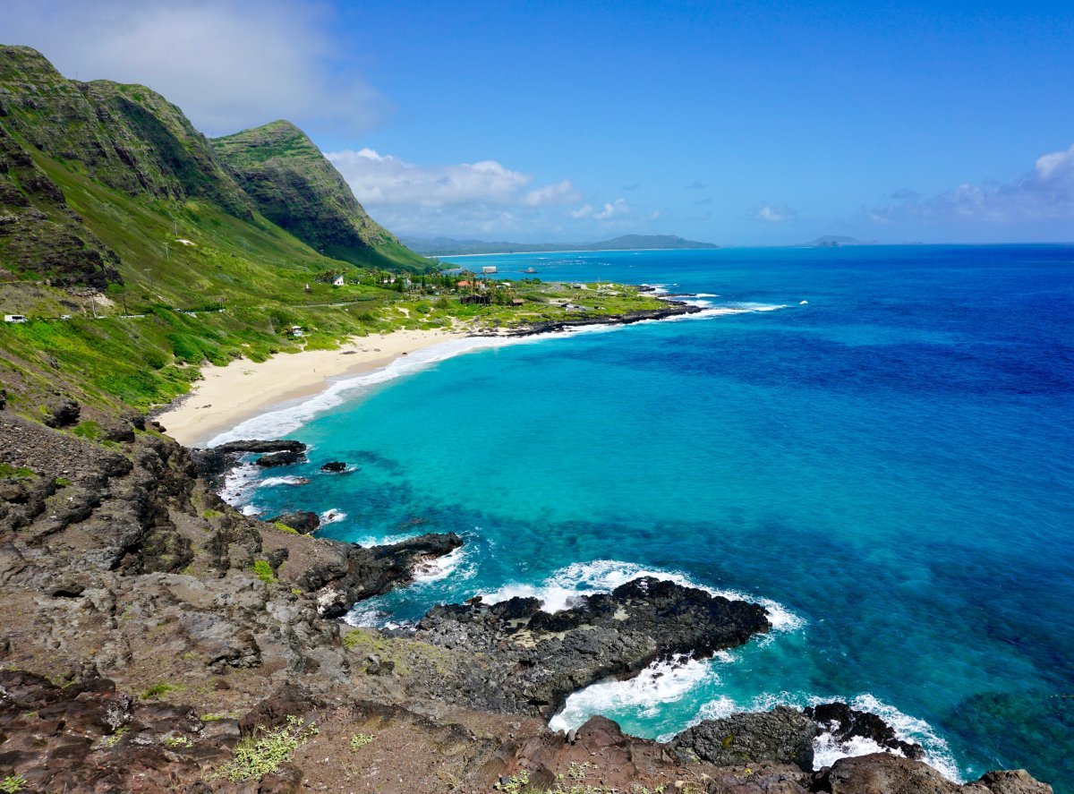 The Windward Oʻahu coast seen from Makapuʻu Lookout, with turquoise water, offshore islets, and the Koʻolau ridge running north.