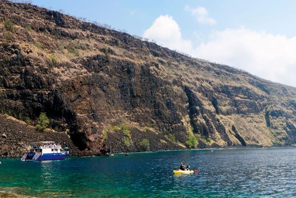 Snorkel boat and kayakers below the cliffs of Kealakekua Bay, Kona
