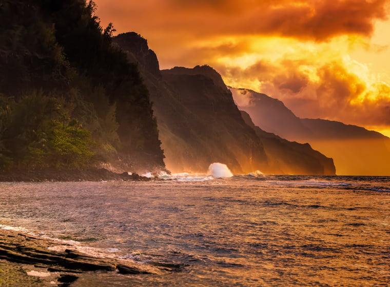 Couple standing together on a Hawaiʻi beach at sunset