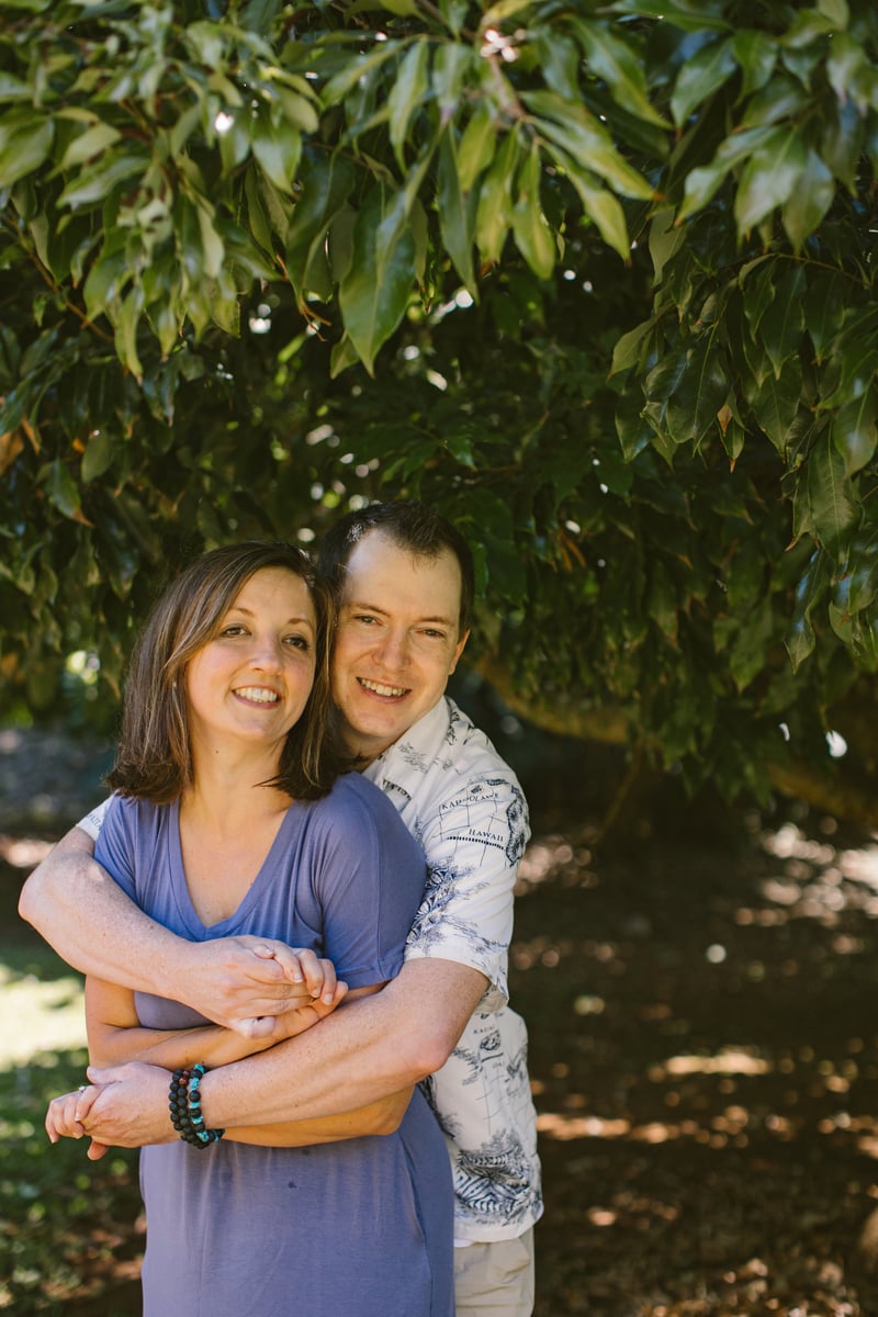 John and Victoria, founders of Hawaii-Guide.com, smiling together under a tree