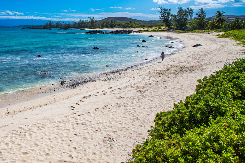Tori walking alone on Makalawena Beach on the Big Island