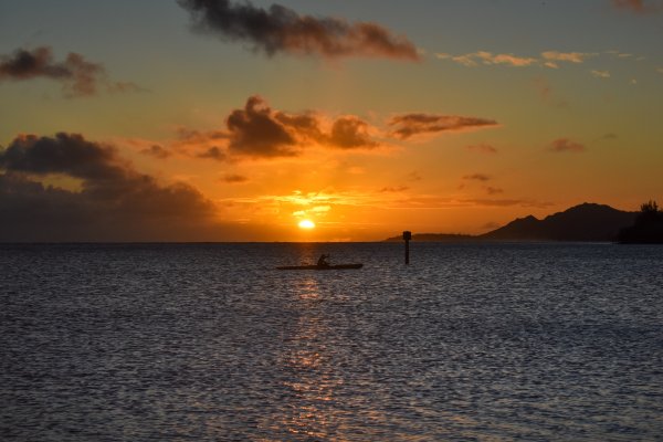 Person kayaking in the water during sunset on an adventure in Maui Hawaii