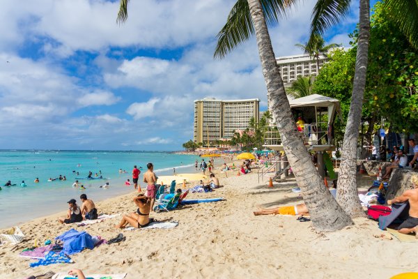 A group of people at Waikiki Beach, one of the most popular beaches to visit in Hawaii