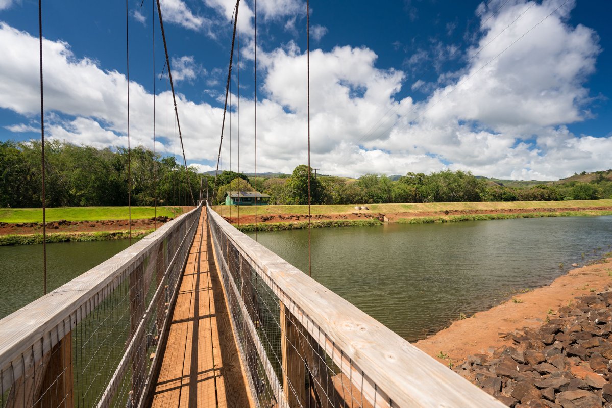 The wooden Hanapēpē Swinging Bridge crossing the river on Kauaʻi