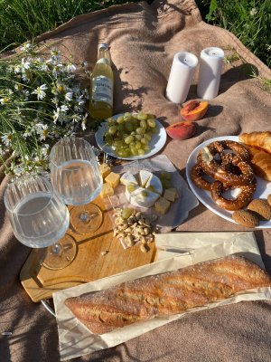 An assortment of drinks and food on a blanket for a sunset picnic in Maui