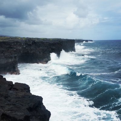 Coastline in Hawaii with waves crashing on a cloudy day.